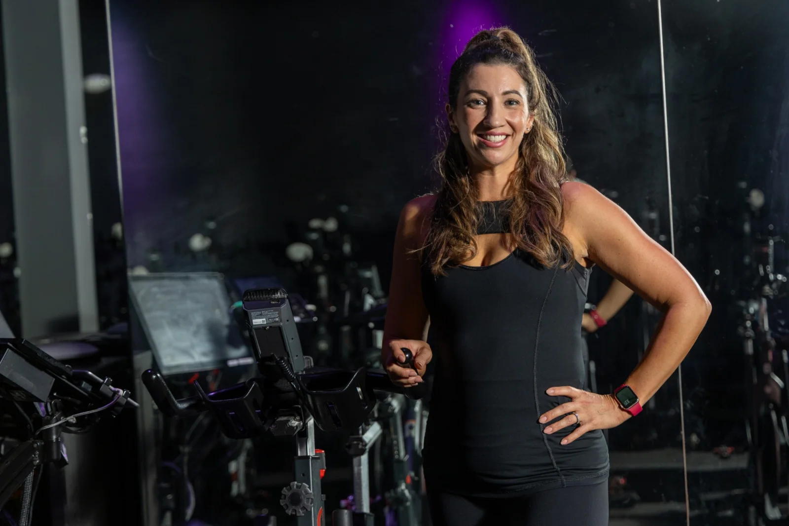 CycleBar Sugar Land instructor smiling beside a bike