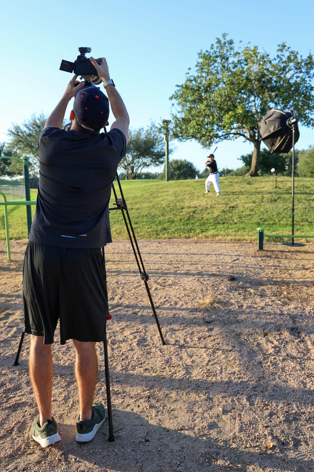Photographer framing a vertical individual portrait on the field