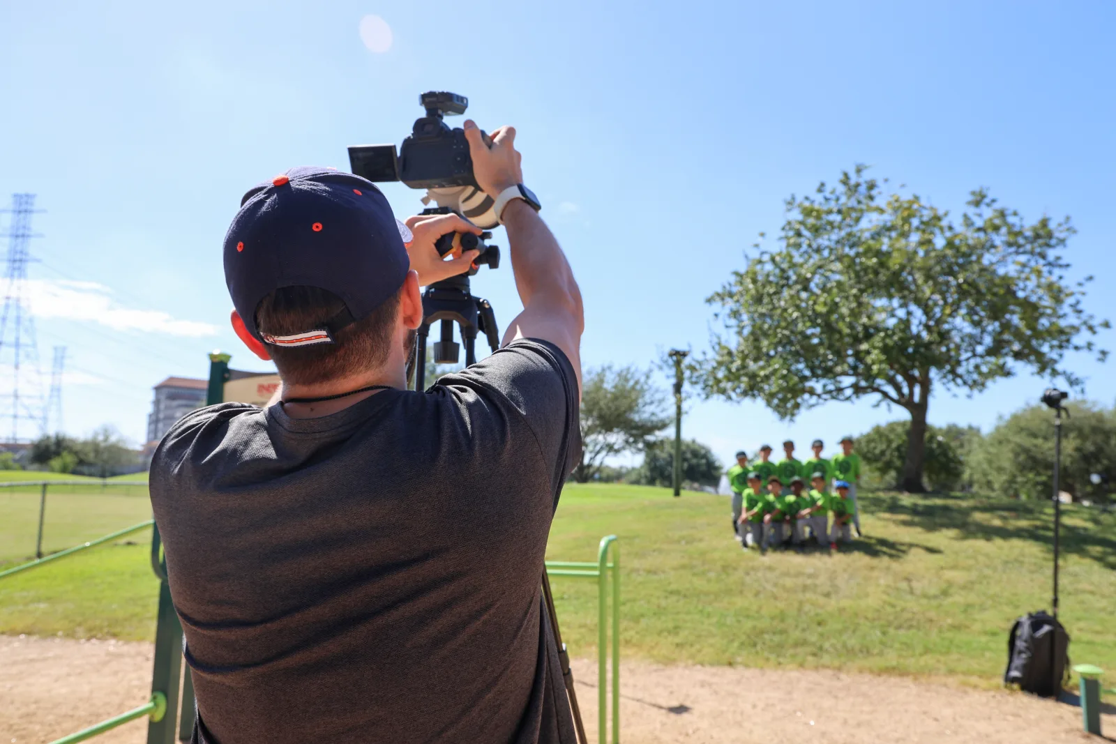 Photographer capturing a team in green jerseys arranged on the hill