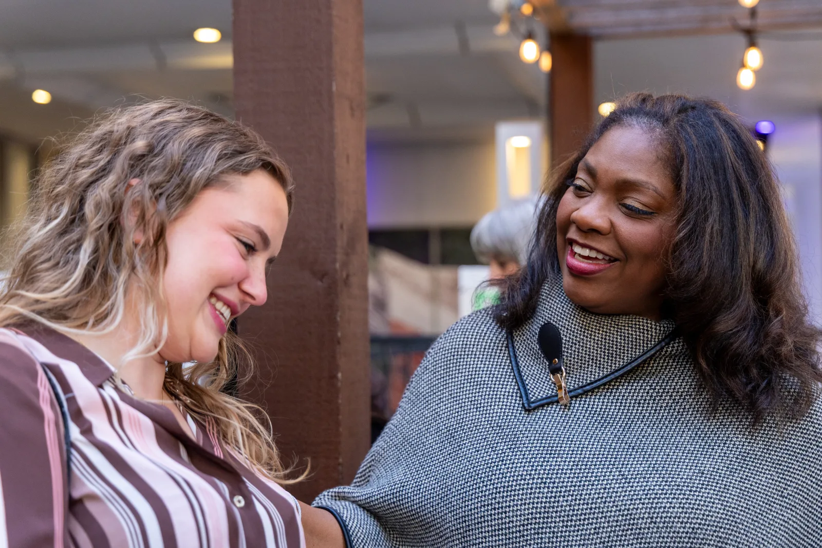 Two attendees laughing during a conversation at the reception