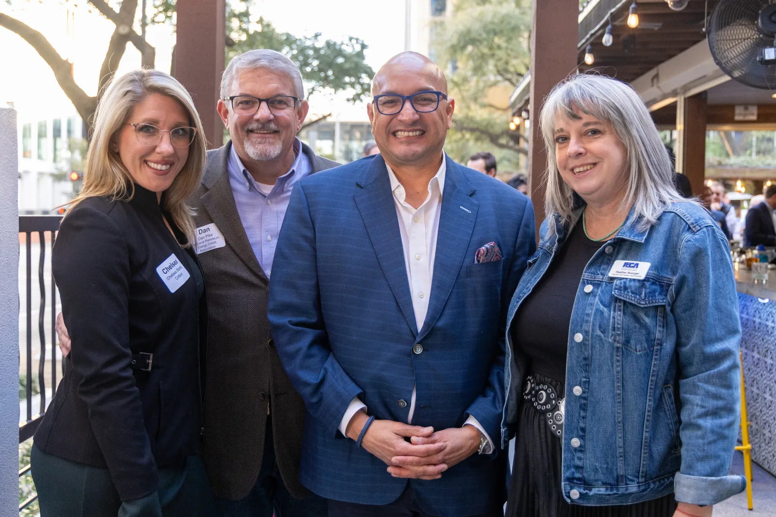 Group of four members posed together on the patio