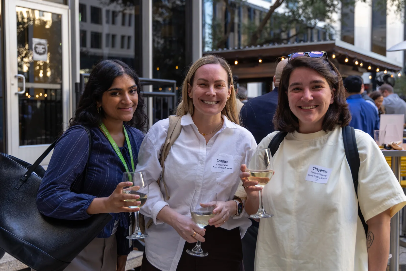 Three attendees posed together with wine at the reception