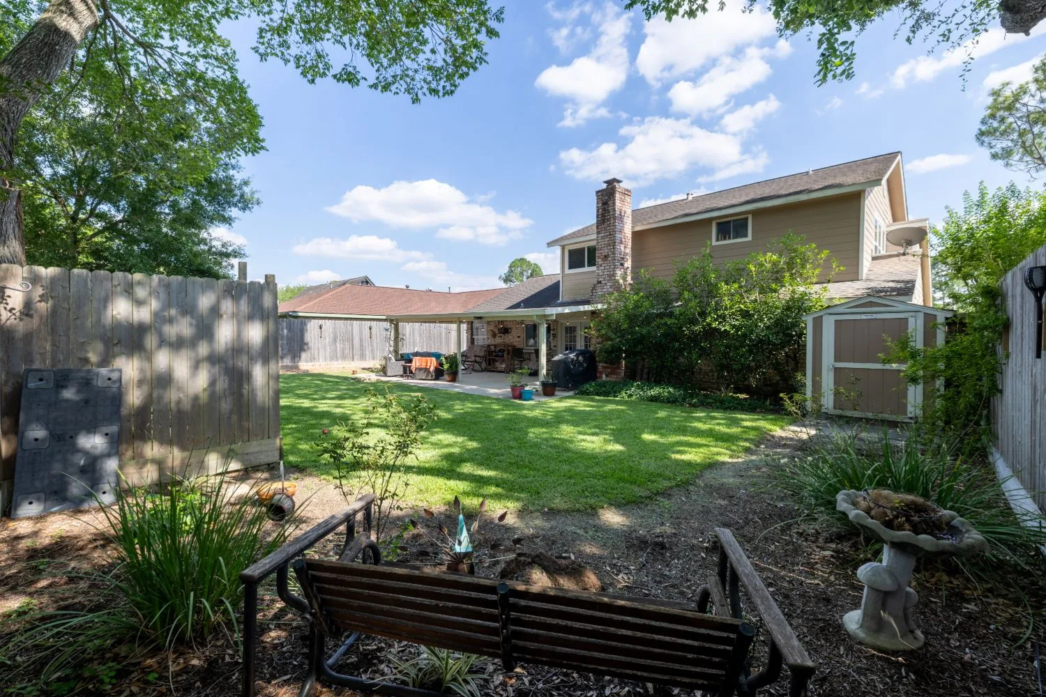 Fenced backyard and covered patio at a Meadows Place listing