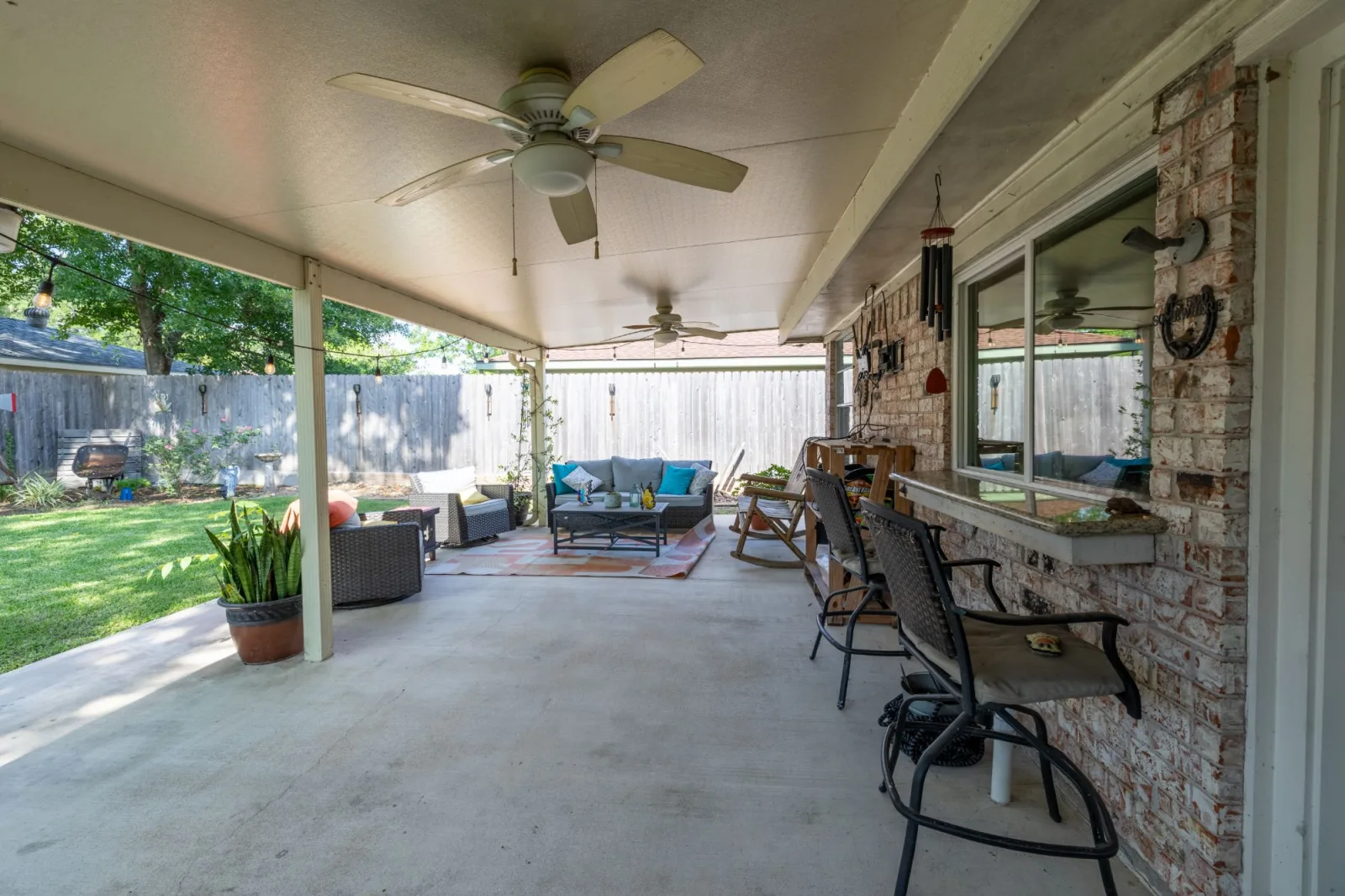 Covered patio living space shot from under the roofline at a Meadows Place listing