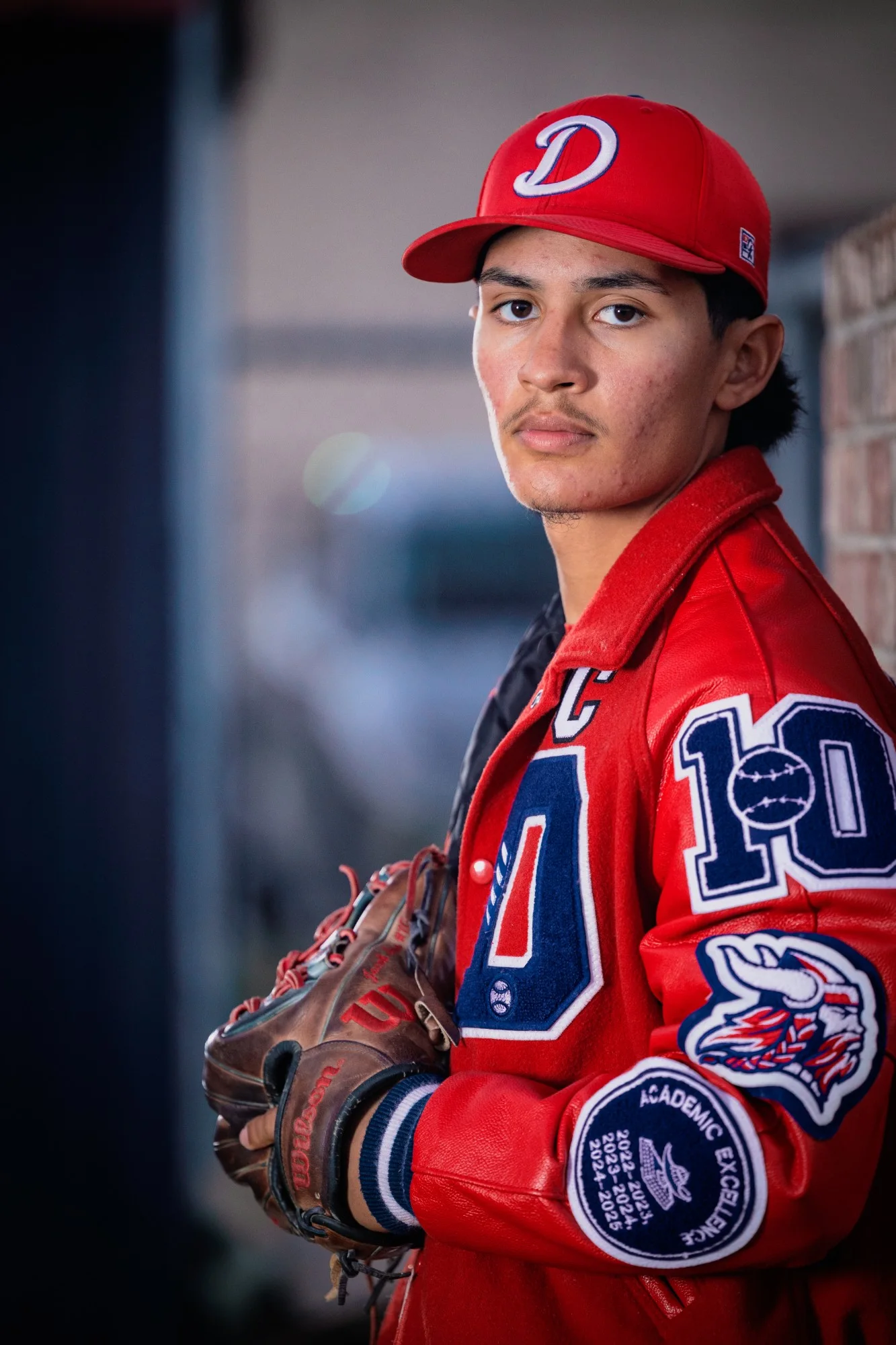 Senior in his letter jacket holding his glove