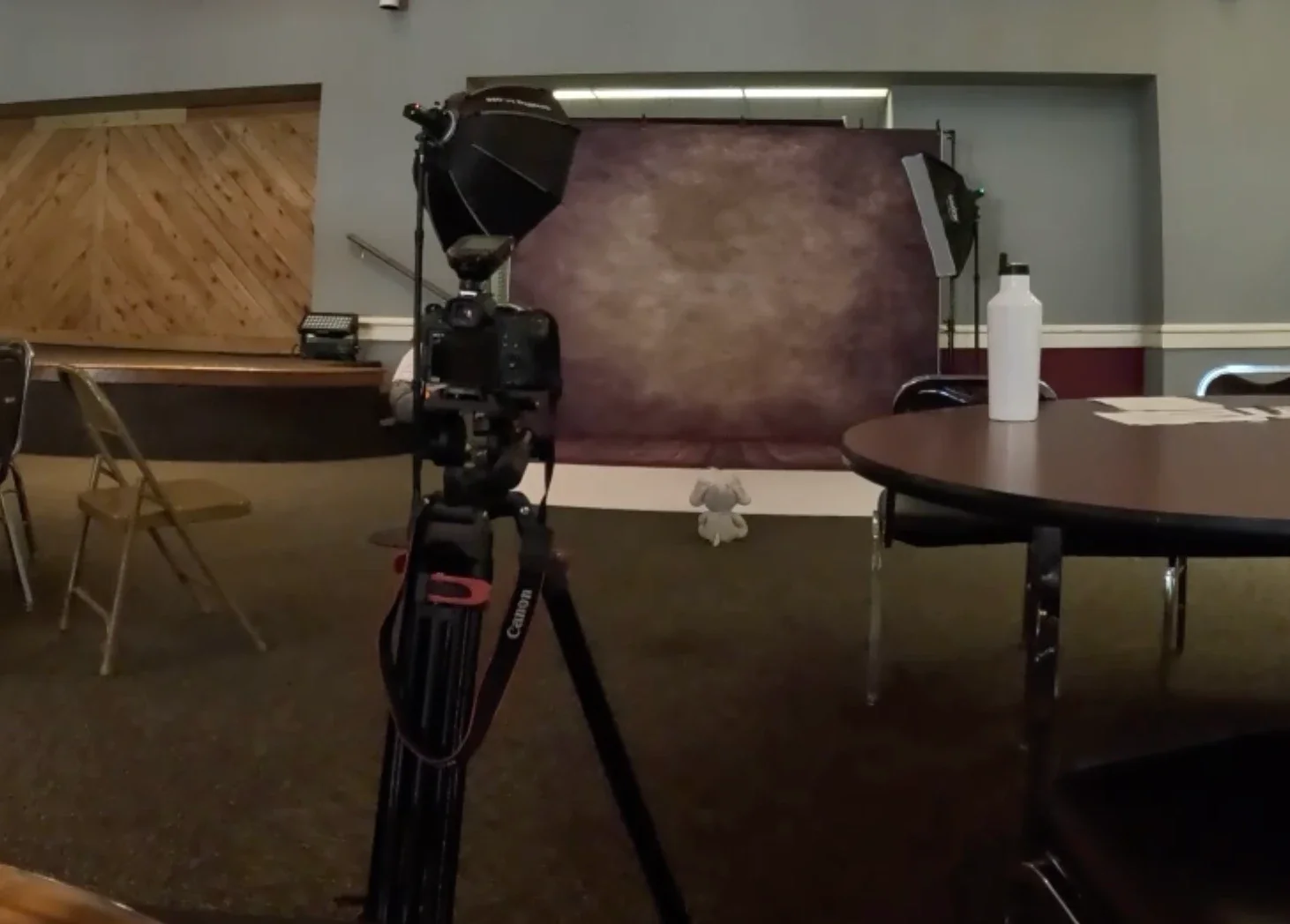JRAM Productions picture day station set up in a school lunchroom with backdrop and studio lighting